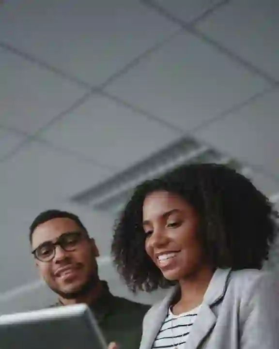 Two young African professionals working on a tablet in a white ceiling office