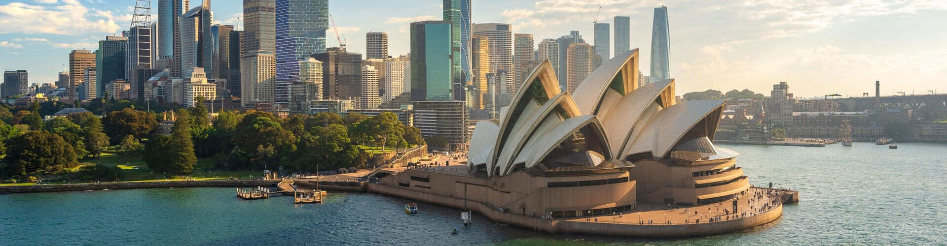 Aerial view of the beautiful and modern city of Sydney, featuring the iconic Opera House on a sunny day.