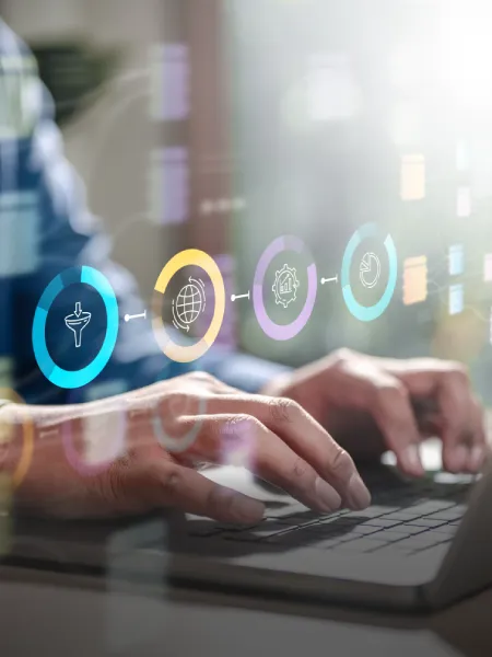 Professional working on a computer with growth analytics icons highlighted on screen.