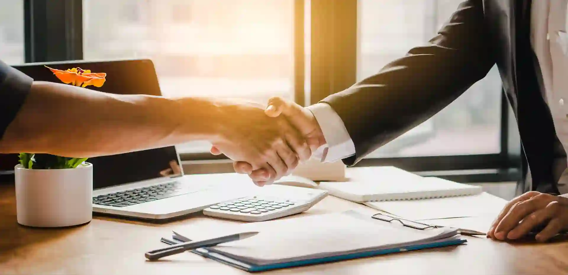 Two businesspeople shaking hands as a sign of a closed agreement, representing TP’s commitment to partnerships.