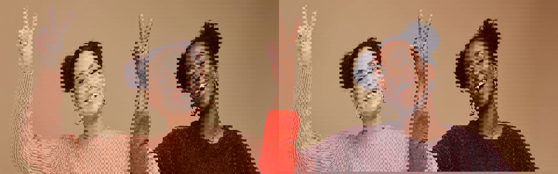 Two cheerful girls smiling and gesturing with their hands towards the camera