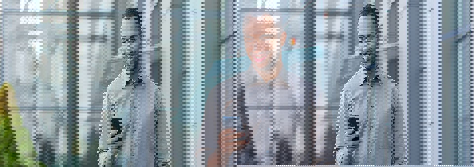 Giovane professionista utilizza lo smartphone in mobilità in un contesto urbano.