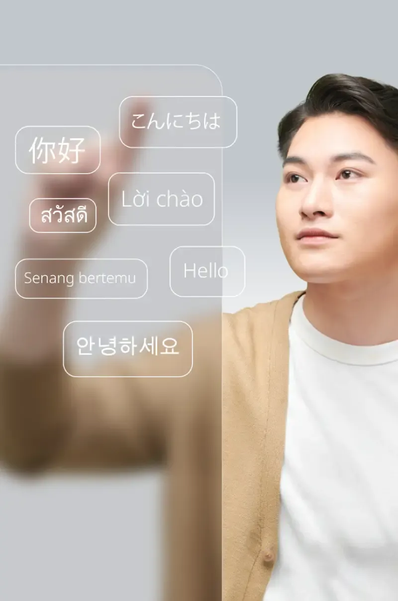 A short-haired young man in a sweater looks up, pointing at the screen.