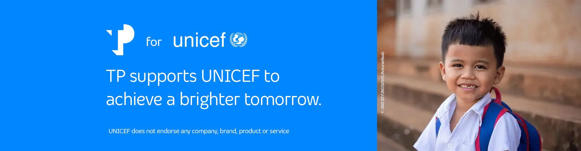 Smiling young boy, next to a blue UNICEF banner with the message supporting a brighter tomorrow.