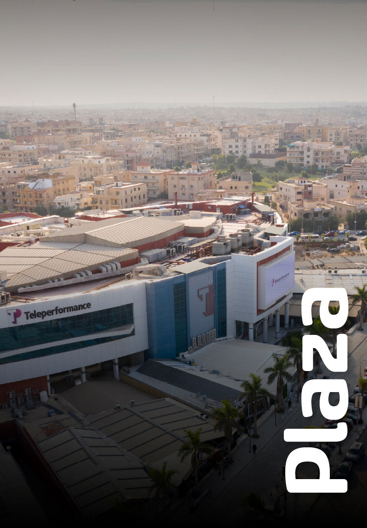 A large shopping mall displays "TP" signage while overlooking a sprawling cityscape. the word "plaza" is prominently featured in bold white letters on the mall's exterior. A large shopping mall displays "TP" signage while overlooking a sprawling cityscape. the word "plaza" is prominently featured in bold white letters on the mall's exterior.